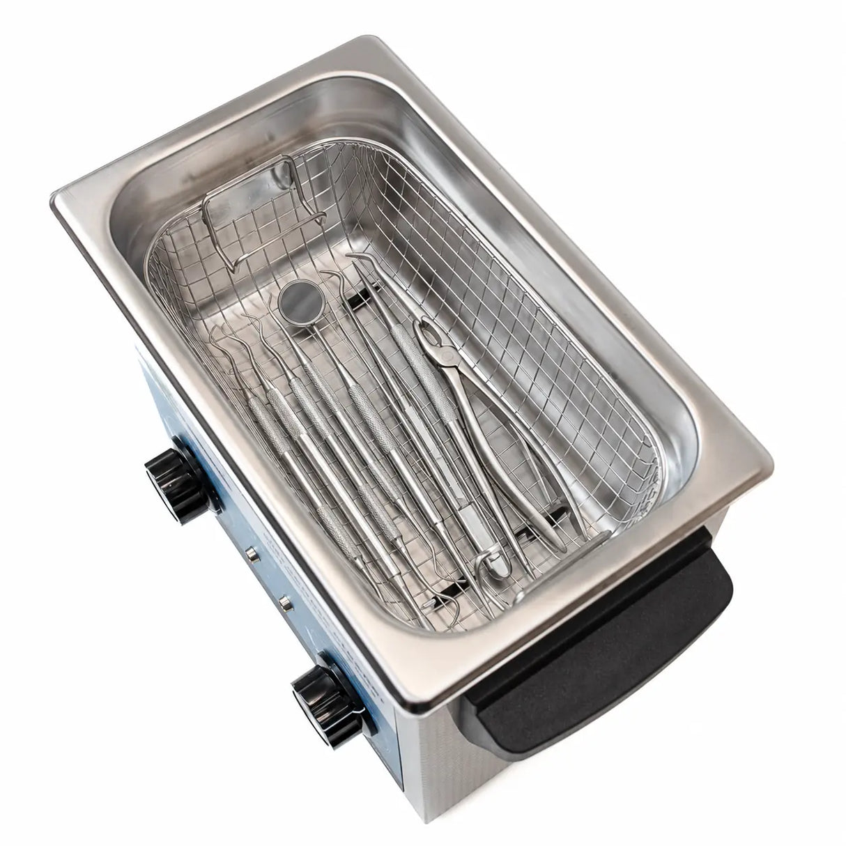 A stainless steel ultrasonic cleaner with a black handle and control knobs, shown with dental instruments, on a white background.