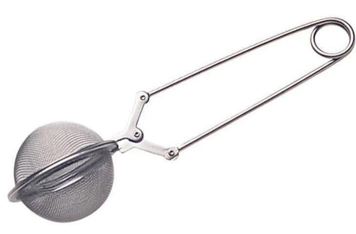 Metallic tea ball strainer on a white background