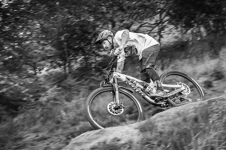 A mountain biker going downhill very fast on a cycle